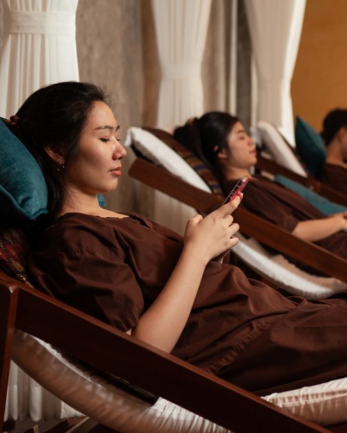 Guests reclining in the foot-spa lounge while therapists work